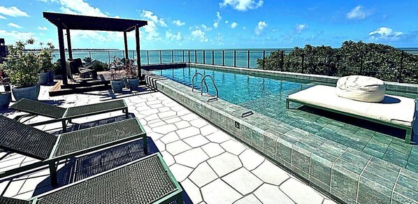 Habitación triple | Piscina | Una piscina al aire libre, tumbonas