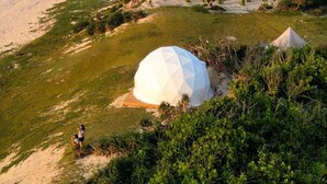 A beach with white dome-shaped tents and a clear view of the ocean. - Batanes Glamping (Sabtang)