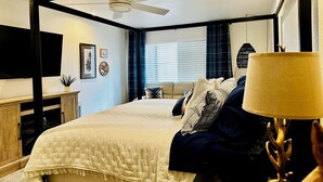 A bedroom with a four-poster bed, a ceiling fan, a bedside table, a lamp, and a window with blinds. - Welcoming 3-bedroom 2 bath condo with WiFi in Pinetop Country Club (Pinetop Country Club)
