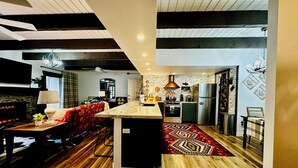 A modern kitchen with a central island, wooden flooring, and a red patterned rug. - Welcoming 3-bedroom 2 bath condo with WiFi in Pinetop Country Club (Pinetop Country Club)