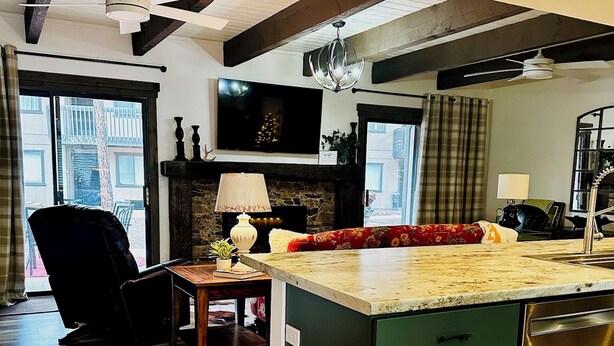 A modern kitchen with a central island, wooden flooring, and a dining area with a chair and table. - Welcoming 3-bedroom 2 bath condo with WiFi in Pinetop Country Club (Pinetop Country Club)