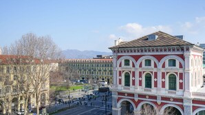 A historic building with a red and white facade, large arched windows, and a central clock tower.