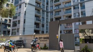 A high-rise residential building with multiple balconies and a sign reading "City Oasis Gardens". - Welcome to Summerville homes ,the cozy haven nestled in the heart of Nairobi. (Nairobi)