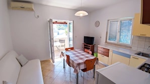 A compact living space with a dining area, kitchenette, and a sofa. - Leana Apartments , island of Brač - One Bedroom (Supetar)