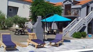Un espace piscine avec des chaises longues et un coin salon abrité.