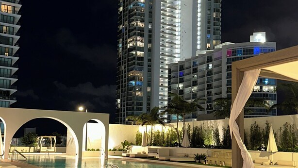 A nighttime view of a hotel pool area with a large building in the background. - Luxe 2bed apartment with AC, fitness room in amazing Miami w/ beautiful sea view (Miami)