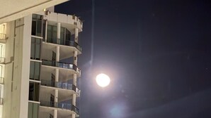 A high-rise building with multiple balconies, large windows, and a visible moon in the night sky. - Luxe 2bed apartment with AC, fitness room in amazing Miami w/ beautiful sea view (Miami)