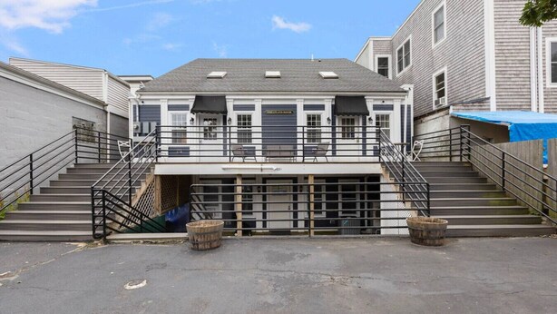 Un bâtiment à deux étages doté d’une entrée de garage, d’un espace extérieur couvert et d’un escalier menant à l’étage supérieur.