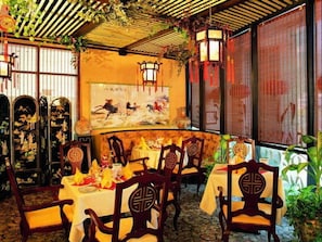 A traditional Chinese restaurant with wooden furniture, a mural, and a bamboo ceiling. - Majestic Central Hotel (Dubai)