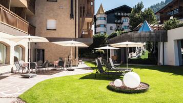 Un patio con mesas al aire libre, sombrillas y una estructura esférica decorativa.