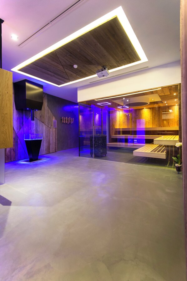 A modern interior with a wooden ceiling, recessed lighting, and a seating area with a glass partition. - Hotel COSMEA Dolomites (Castelrotto)