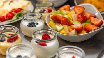 A variety of food items including yogurt with berries, a bowl of mixed fruits, and other dishes.
