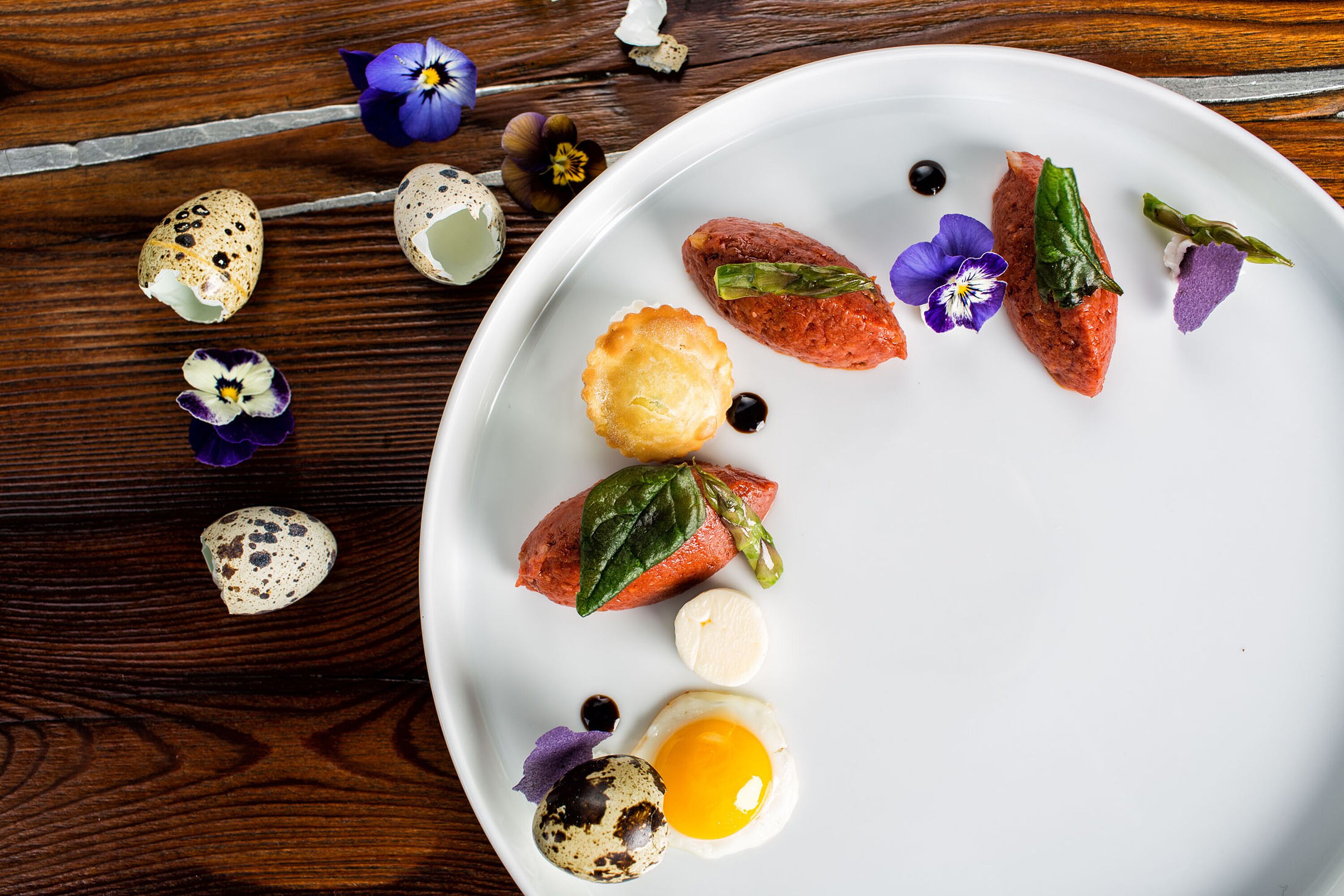 A white plate with food items and decorative elements on a wooden surface.