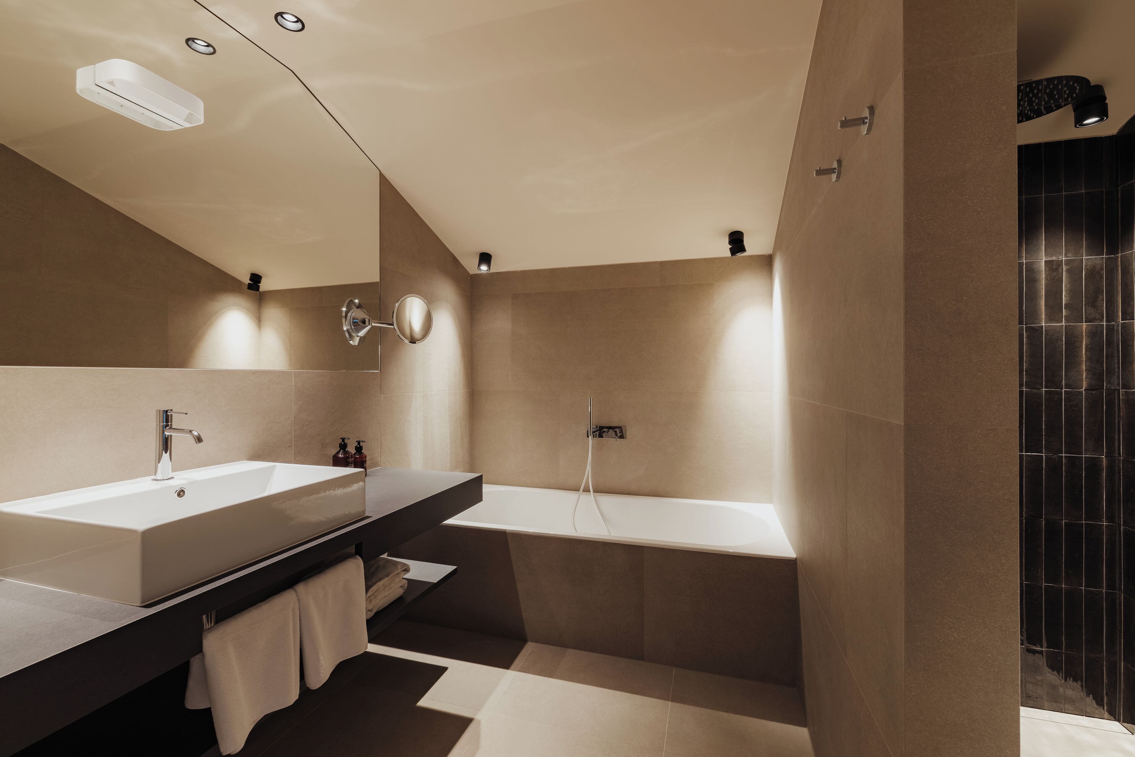 Een moderne badkamer met twee wasbakken, een badkuip en een douche.