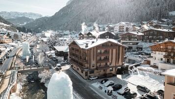 Een bergstad bedekt met sneeuw, met houten gebouwen, een rivier en een grote ijsformatie.