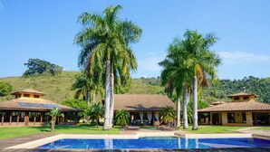 Un complejo turístico con piscina, palmeras y varios edificios con techos de tejas.