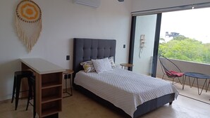 A bedroom with a bed, a desk, and a chair. - Studio in Centro Maya area of Playa Del Carmen-full kitchen, AC, smart TV, pool. (Playa del Carmen)
