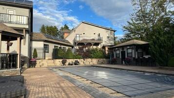 Un barrio residencial con piscina, una casa de dos pisos y un patio.