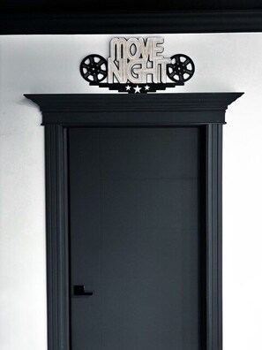 Una porta tancada amb un cartell a dalt que diu 'MOVE NIGHT' i presenta dues rodes.