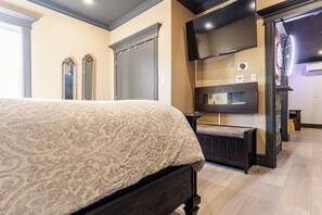 A bedroom with a bed, a TV mounted on the wall, and a wardrobe.