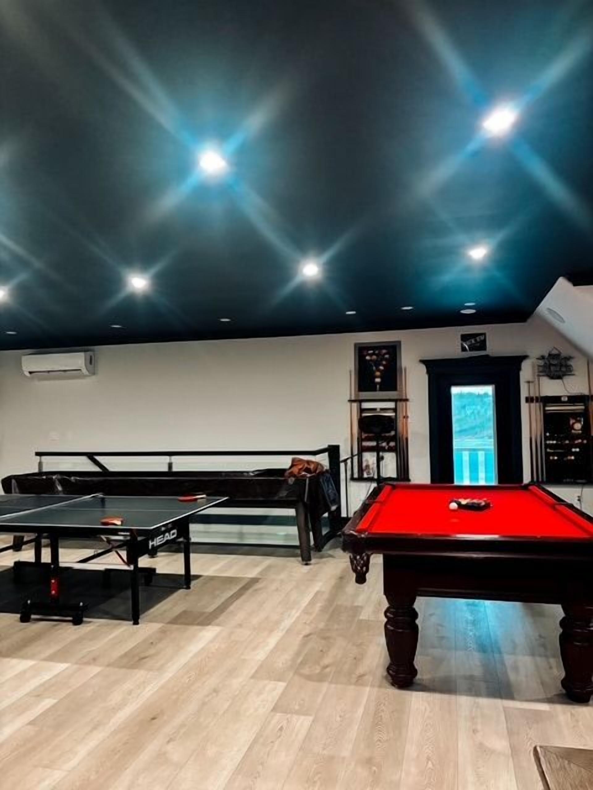 Una sala de billar con mesa de billar, mesa de snooker y dardos.