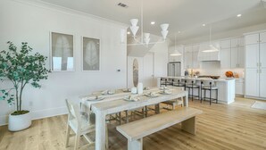 A modern kitchen with white cabinets, a central island, and pendant lighting.