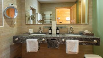 A modern bathroom with two sinks, a mirror, and a vanity.