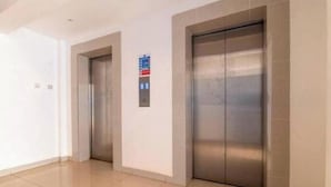 Un espace moderne pour les ascenseurs, comprenant deux ascenseurs et un panneau de commande.