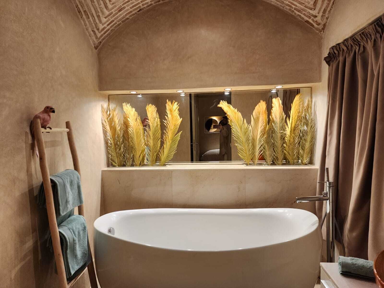 A bathroom with a freestanding bathtub, a vanity with a mirror, and a towel rack.