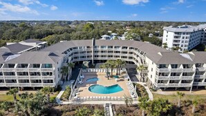 Un hôtel doté d’une cour intérieure avec une piscine, de nombreux balcons et une vue sur le paysage environnant.