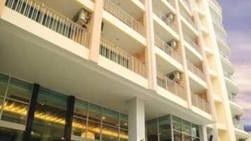 A multi-story hotel with balconies, large windows, and a modern architectural design.