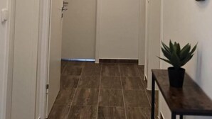A hallway with a wooden floor, white walls, and a ceiling light fixture. - Quiet time out in Soltau (Soltau)