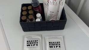 A bathroom sink with a black soap dish containing various toiletries, a white towel, and two makeup remover wipes. - Apartment 3 B (Emilia-Romagna)
