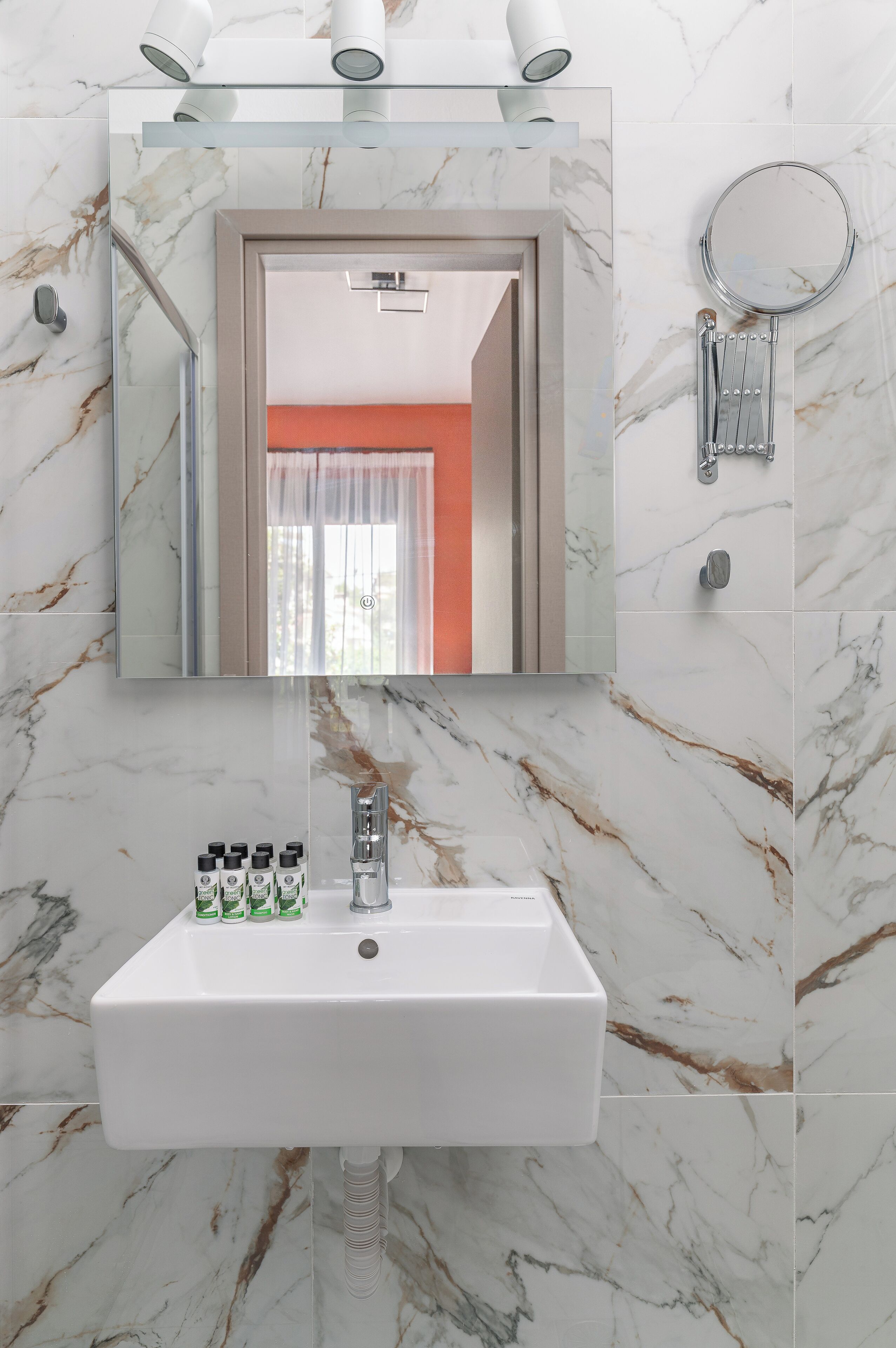 A bathroom with a white sink, a mirror, and a shower.