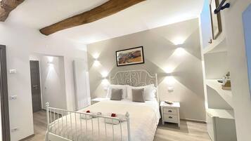 Une chambre à coucher avec un lit, des tables de chevet, un radiateur et un tableau au mur.
