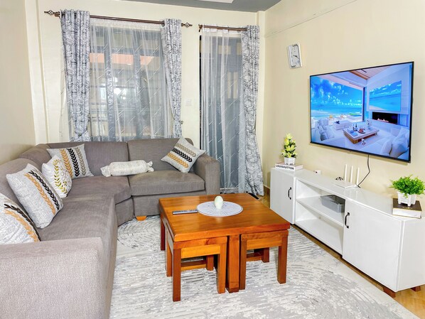 A living room with a sofa, a coffee table, a TV, and a cabinet.