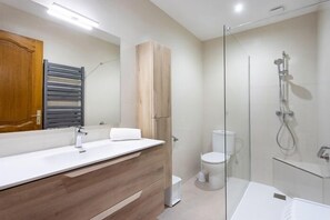 A modern bathroom with a wooden vanity, a glass shower enclosure, and a white toilet. - Neptuno Ocean Experince by Sydney (Puerto de Santiago)