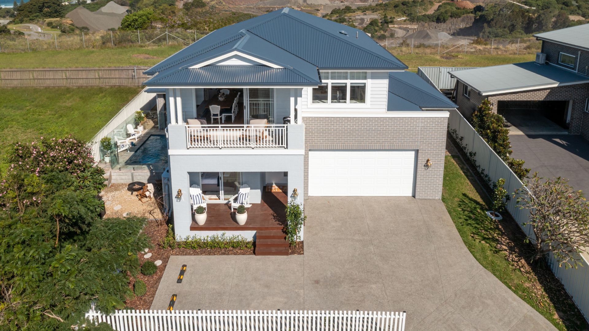 Une maison à deux étages avec un balcon, un garage et une piscine.