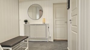 A hallway with a bench, a radiator, a mirror, and a door. - Newly renovated apartment in Skärhamn within walking distance to the beach | SE09138 (Skärhamn)