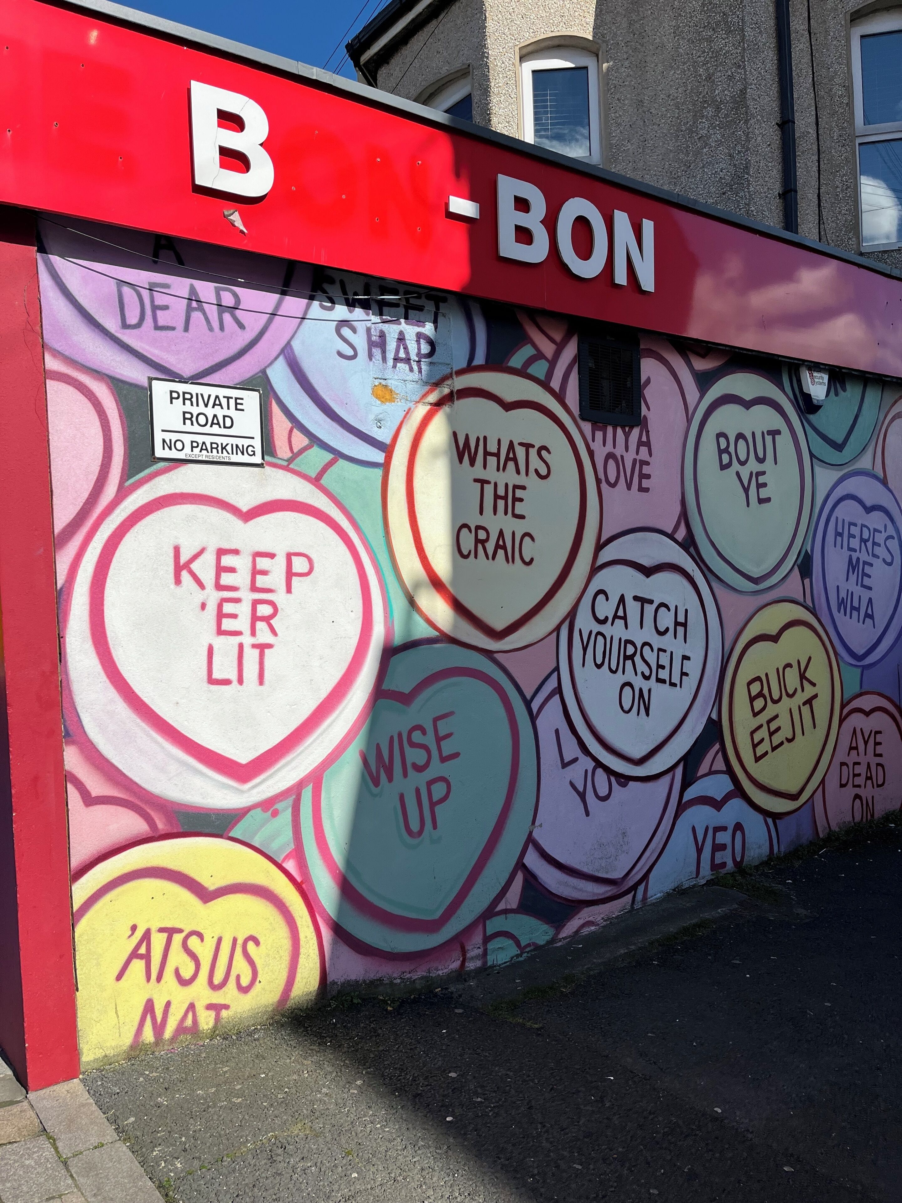 A wall with a red sign reading 'BON' and a private road sign.