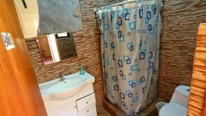 Une petite salle de bain comprenant un lavabo, un miroir et des toilettes.
