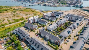 A residential area with modern houses, a marina, and a bridge in the background.