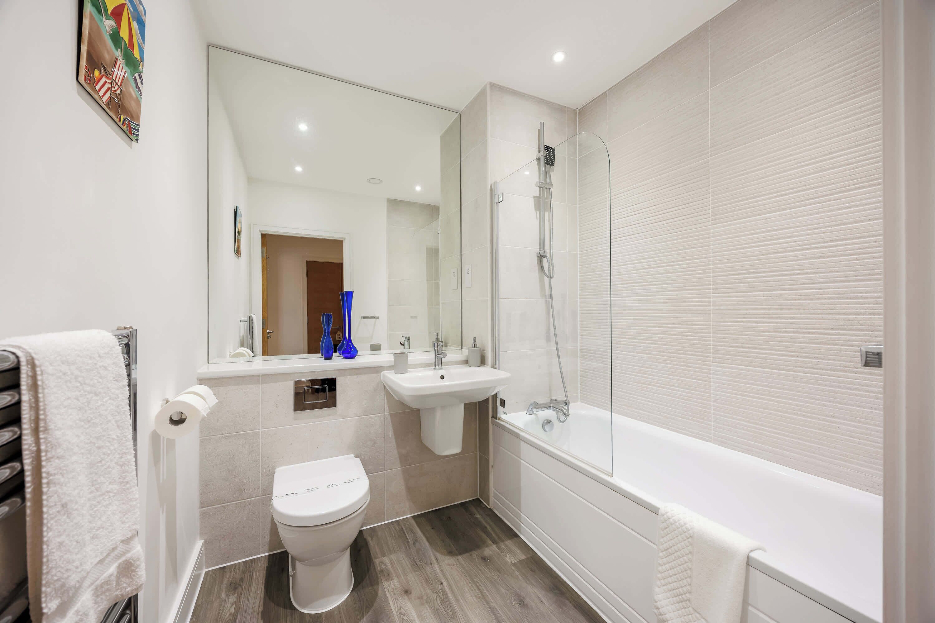 Une salle de bain moderne équipée de toilettes, d’un lavabo et d’une baignoire.