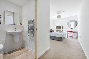 Une salle de bain moderne avec un lavabo, un miroir et un porte-serviettes.