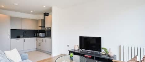 A modern apartment with a living room, kitchen, and dining area.
