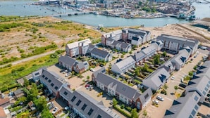 An aerial view of a residential area with modern houses, a marina, and a river. - Sun-Soaked - Charming Views Overlooking the Harbour (Poole)