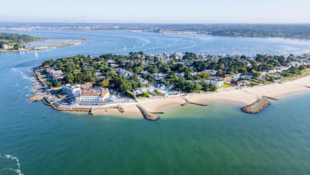 An aerial view of a coastal town with a marina, beach, and residential area. - Sun-Soaked - Charming Views Overlooking the Harbour (Poole)