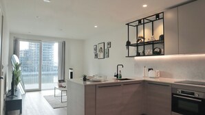 Una cocina moderna con una isla central, horno integrado y un amplio ventanal con vistas a la ciudad.