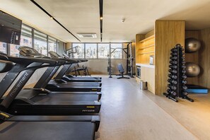 A gym with treadmills, weight machines, and a rack of dumbbells. - Charlie Skyline Moinhos (Porto Alegre)