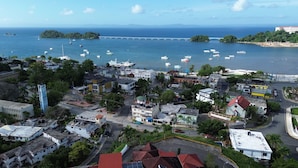 A coastal town with a marina, buildings, and a bridge in the background. - Hotel & Restaurant Chino (Samaná)